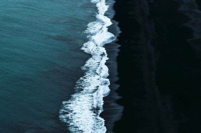 Sea coast dark sand Marina footer image 2-min